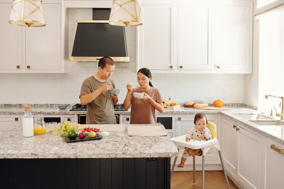 A kitchen with a stove and gray counters.
