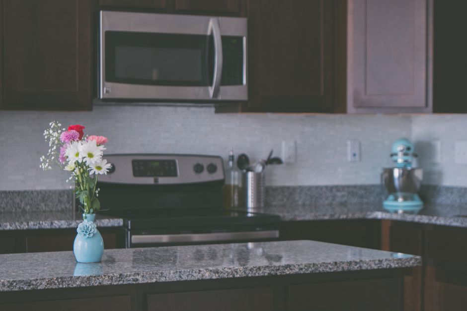 A kitchen with granite countertops and cabinets.